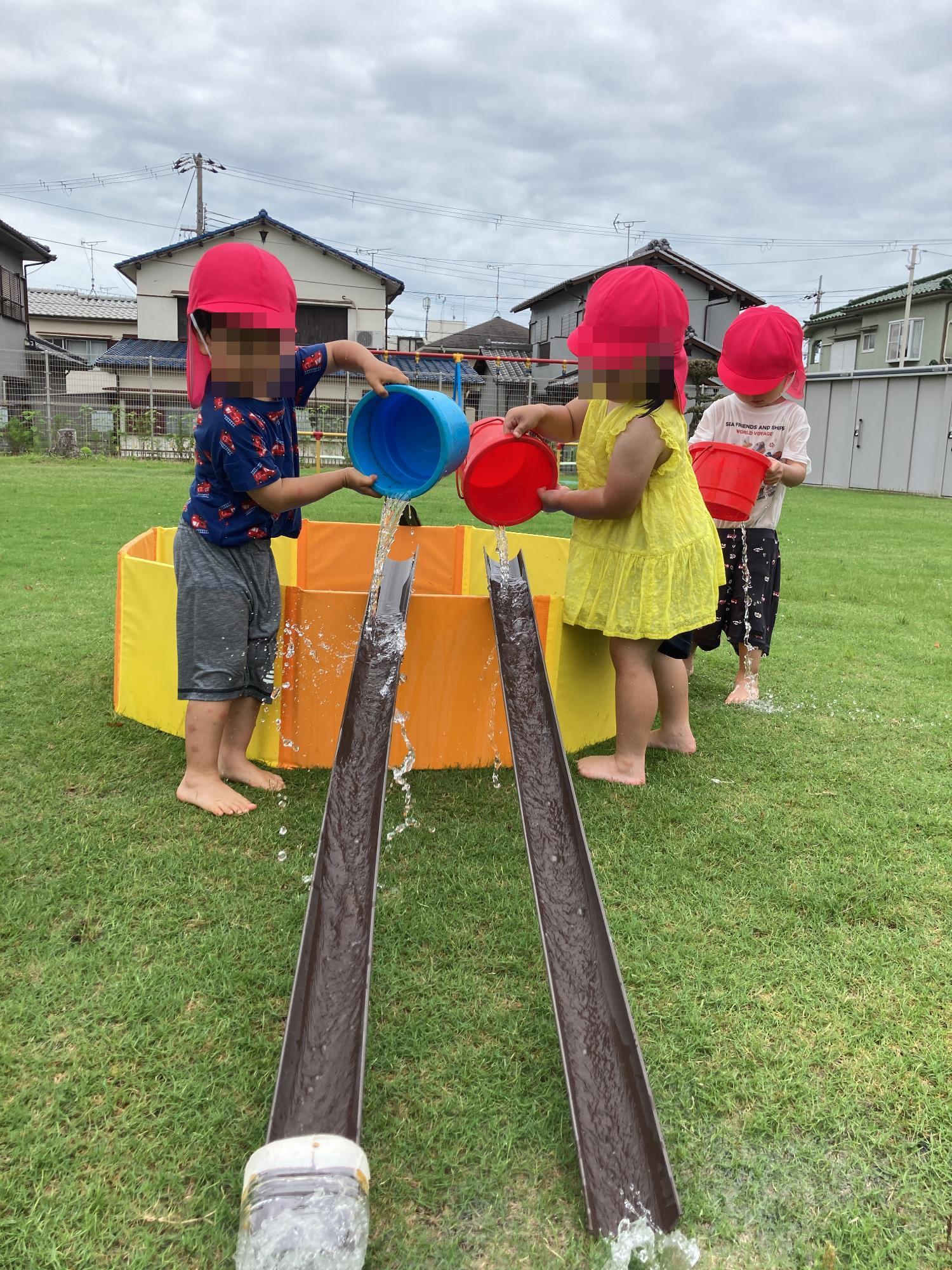 桶に水を流す幼児